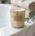 Hochwertige Duftkerze Antico Marble im Marmor-Look auf dem Wannenrand in einem luxuriösen Spa-Badezimmer mit Handtüchern und Eukalyptus – Wellness für zu Hause von Best Bougie
