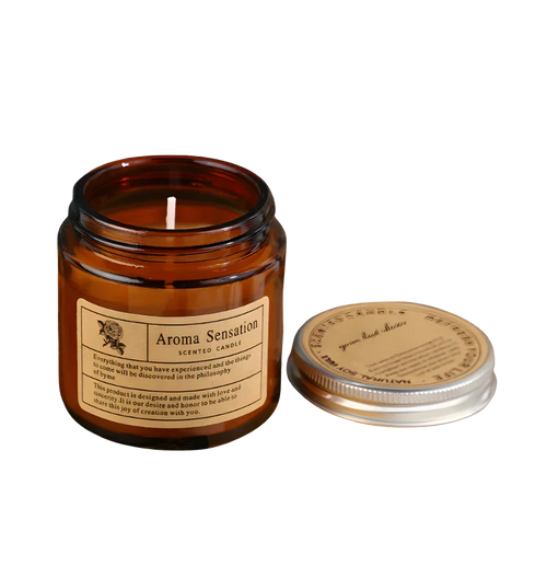 Hochwertige Aroma Sensation Duftkerze im Braunglas mit silbernem Deckel. Hände präsentieren die Kerze zusammen mit einer prachtvollen roten Rose und frischen Rosenknospen im Torn-Paper-Look durch ockerfarbenes Papier – Best Bougie floraler Premium Wohnduft.