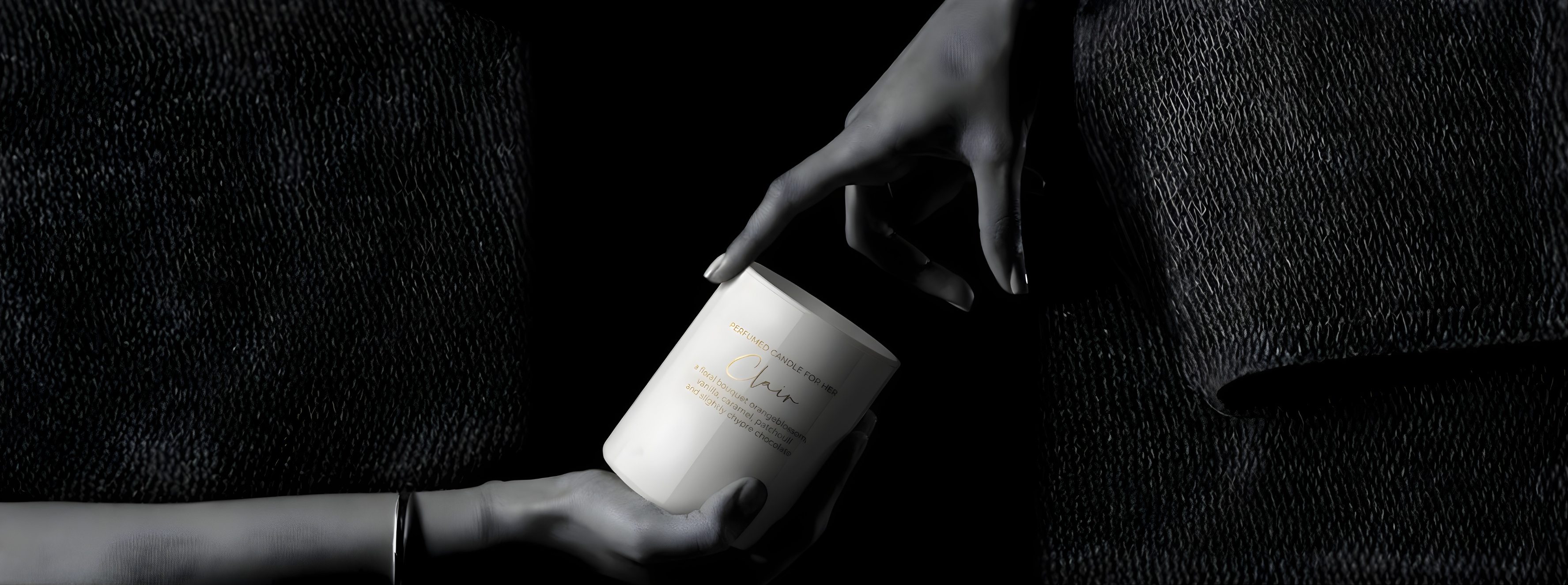Edle weiße Clair Duftkerze „For Her“ in einer eleganten Low-Key-Aufnahme. Eine Hand präsentiert das matte Glas mit goldener Schrift, während eine zweite Hand die Kerze von oben zart berührt – Best Bougie luxuriöser Raumduft mit Noten von Vanille, Karamell und Patchouli.